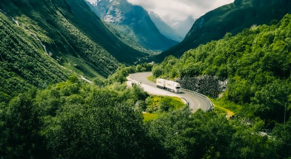 En trailer för Collicare som kör genom Italiens gröna landskap med varor och gods.