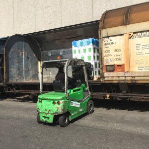 Forklift unloading a train filled with cargo, at the final destination.