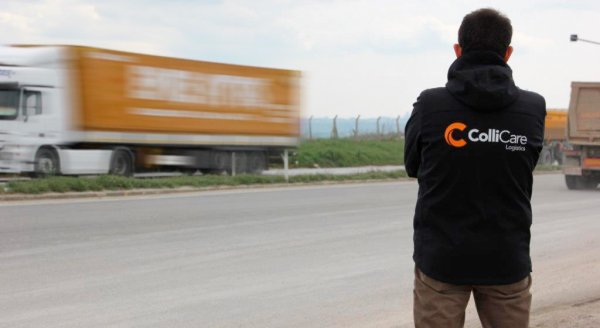 ColliCare employee on the side of the freeway watching the trailers passing by filled with goods